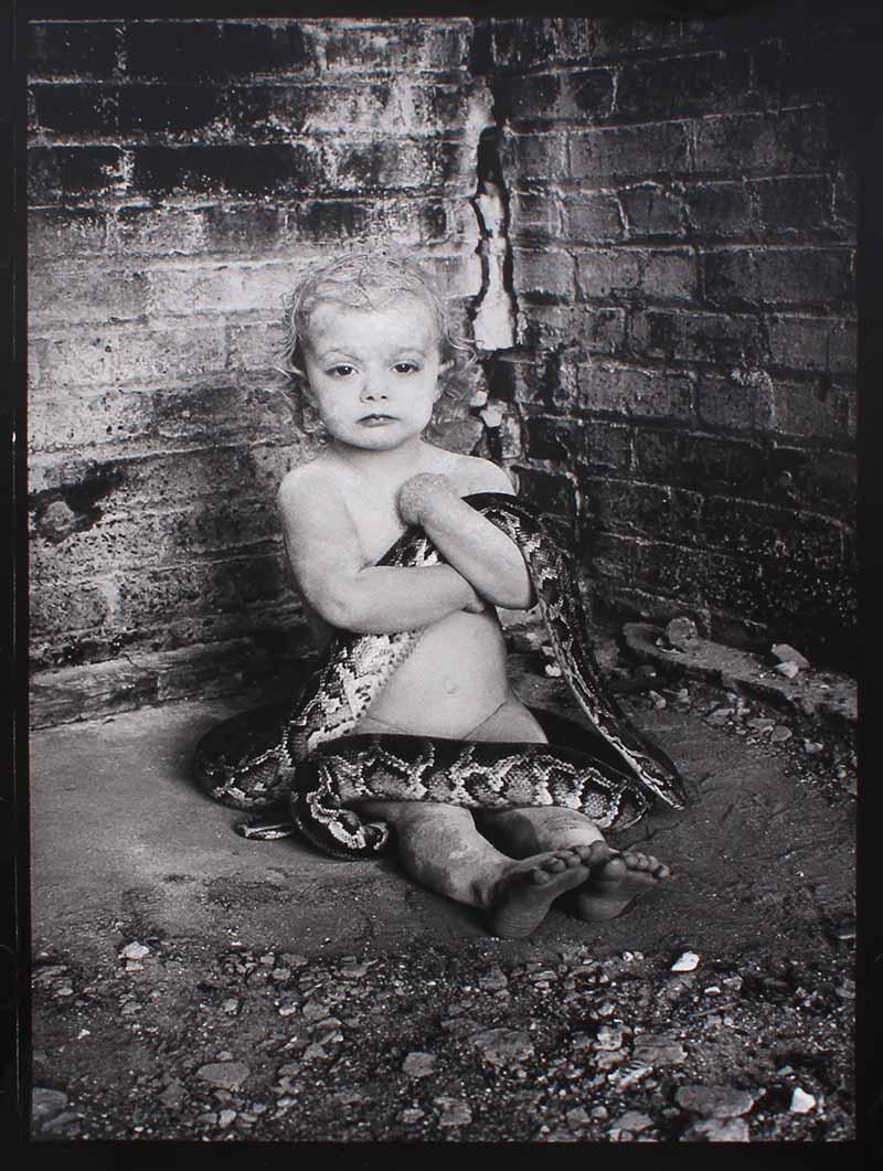 Nina Glaser (b. 1955) Santa Fe, New Mexico: BABY WITH SNAKE, gelatin silver print, signed and dated and numbered 3/50 in ink on verso, sheet 36 ¾ x 25 ½”.