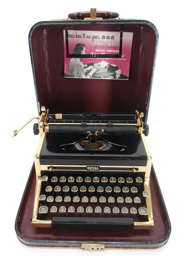 Decorative Art: Royal Traveler Portable Typewriter: GRAY MAGIC, 1949, a black enamel typewriter with high-polished golden metal trim, with original leather sturdy case and operating manual, some light surface scratches associated with age and use, in w