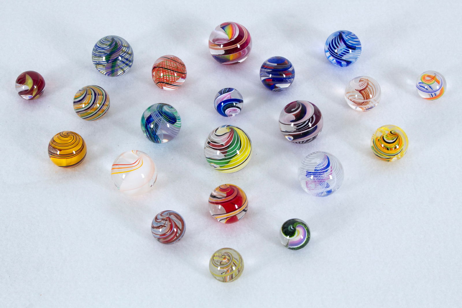 Art Glass Marbles Artists or Studios Unidentified (twenty-one): Collection of clear and color glass marbles, signatures or studio markings not found, sizes from 1 ½” diameter to 1” diameter. (21)
