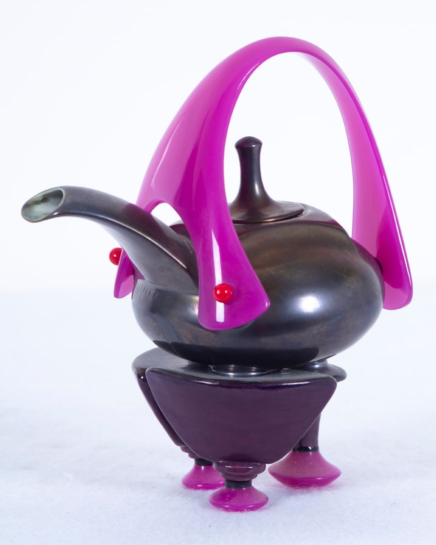 Donald Frith (b. 1924) American: Dark body with fuchsia feet, painted and glazed footed ceramic teapot with molded fuchsia acrylic handle, signed under the spout, 7 ¼” tall, 6 ½” wide. Acquired from/ Provena