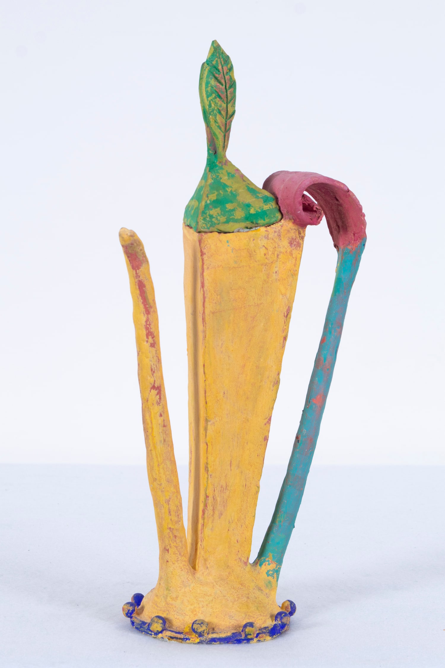 Linda Hoffhines (20 th Century) American: Tall yellow with leaf-like top, painted ceramic teapot, 15 ½” tall, 7” wide. Acquired from/ Provenance: Santa Barbara Museum April 1999.