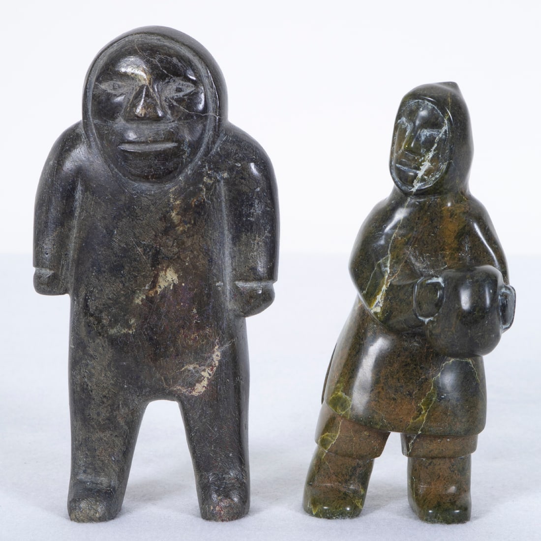 Inuit Art: Tungilik & Nagjoogak (two): MAN, 1973, carved steatite, signed underneath, 7” tall; MAN CARRYING STONE, 1972, carved serpentine, signed underneath, 6 ½” tall, Provenance: From the collection of Museum of River