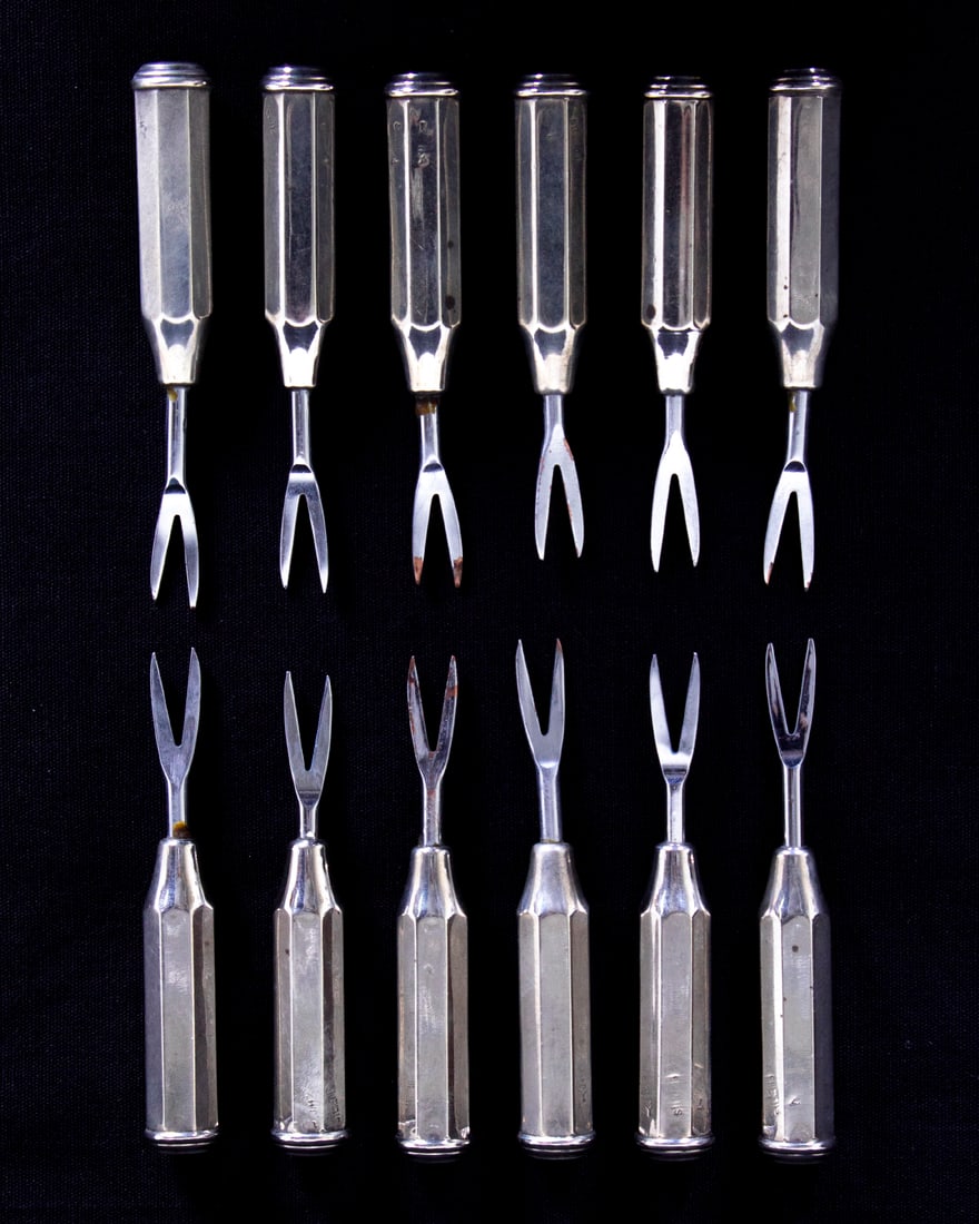 Sterling Silver hors d’oeuvres forks (set of twelve): Set of twelve two-prong hors d’oeuvres forks with sterling silver handles and stainless tines, all stamped, average length approximately 3 ¼”, in velvet lined leather case.