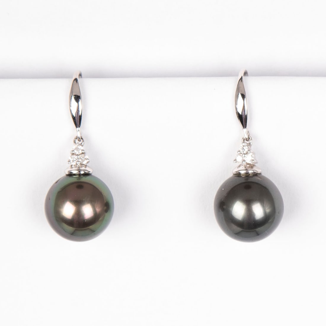Jewelry: 18k White Gold Black Tahitian Pearl and Diamond Earrings: 18k white gold earrings with round pearls measuring 11 mm each, surrounded by 6 bead-set diamonds, each VS-1, color G, weighs 4.9 grams. Display/box not included.