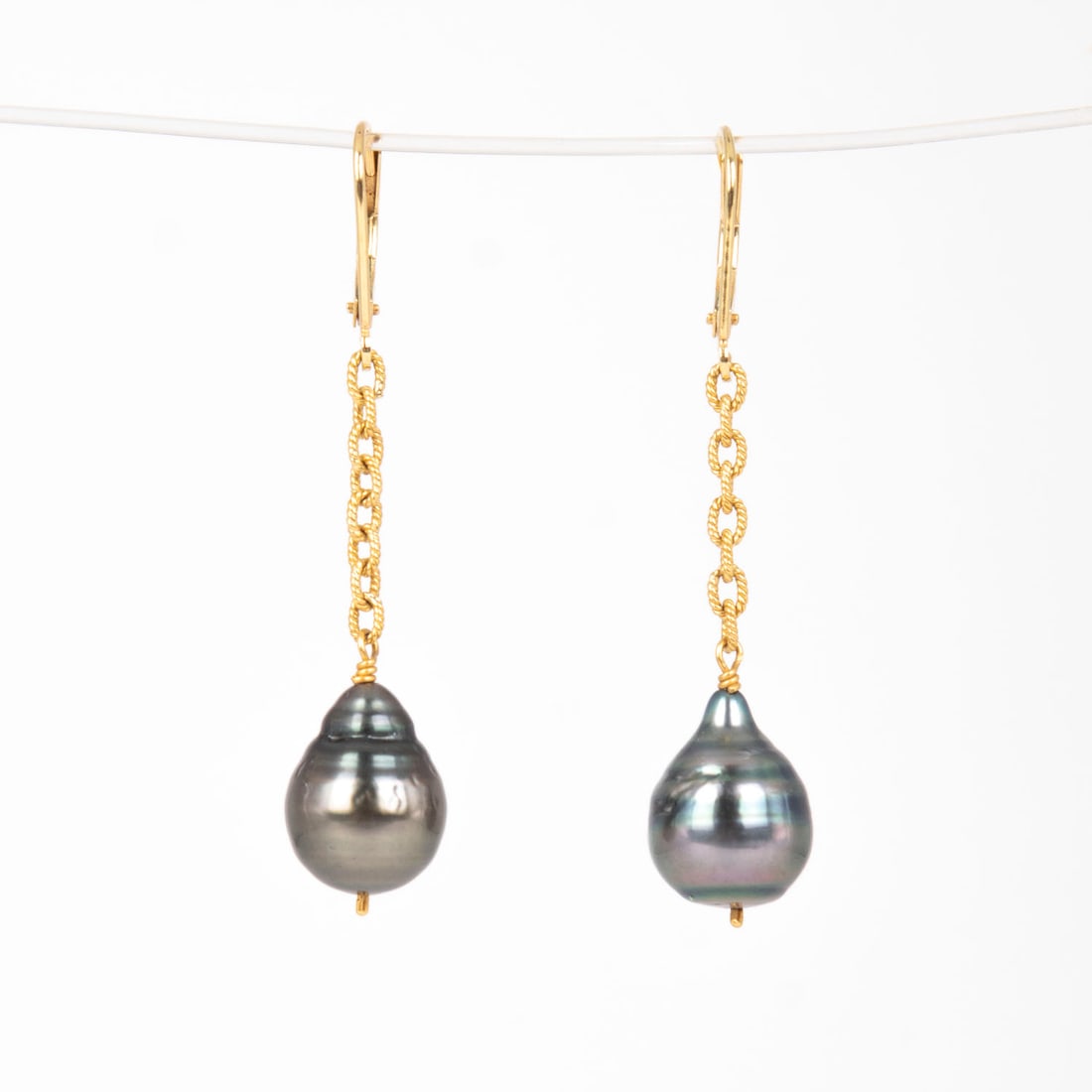 Jewelry: 18k Yellow Gold and Black Tahitian Pearl Earrings: 18k yellow gold earrings with pear-shaped pearls, each approximately 10 mm, stamped, 41 mm length, weighs 4.8 grams. Display/box not included.