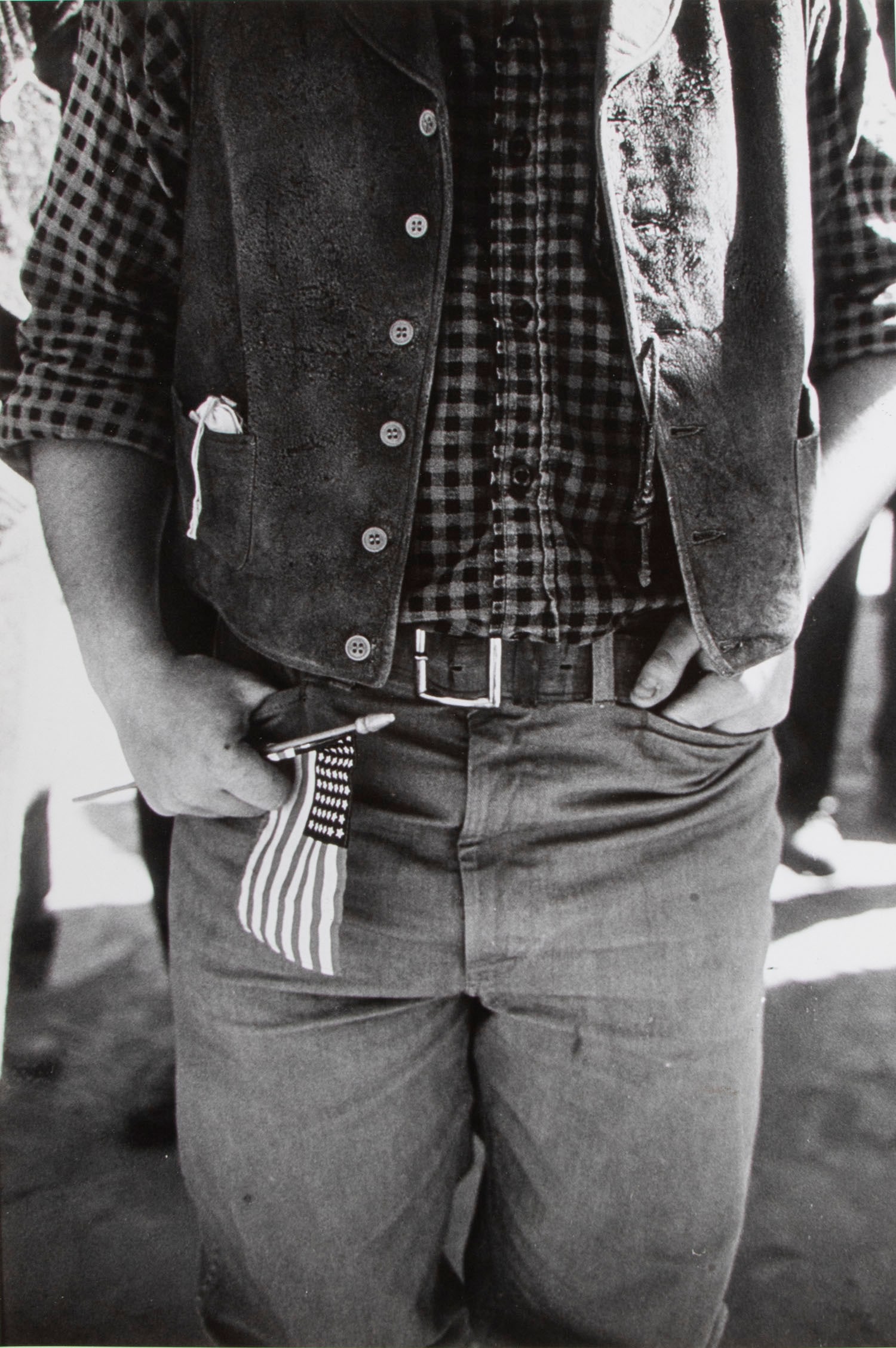 Lawrence Schiller (b. 1936) New York: MAN CLUTCHING A SMALL AMERICAN FLAG from the Hollywood Series, c. 1960’s-70’s, gelatin silver print, artist’s/agency and Transworld Feature Syn stamps and on verso, image 13 3/8 x 9”, shee