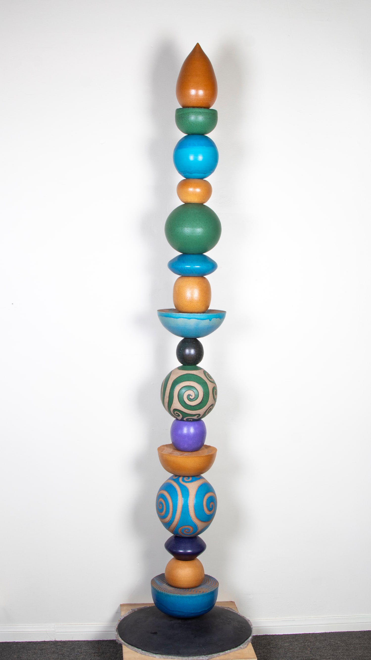 Ceramic Artist Unidentified (20th Century) possibly the work of David Atkinson of South Island New Z: ROUND TOTEM, sixteen painted and glazed ceramic slotted elements stacked on metal pole with base, height 83”, base diameter 19”, a signature not found.
