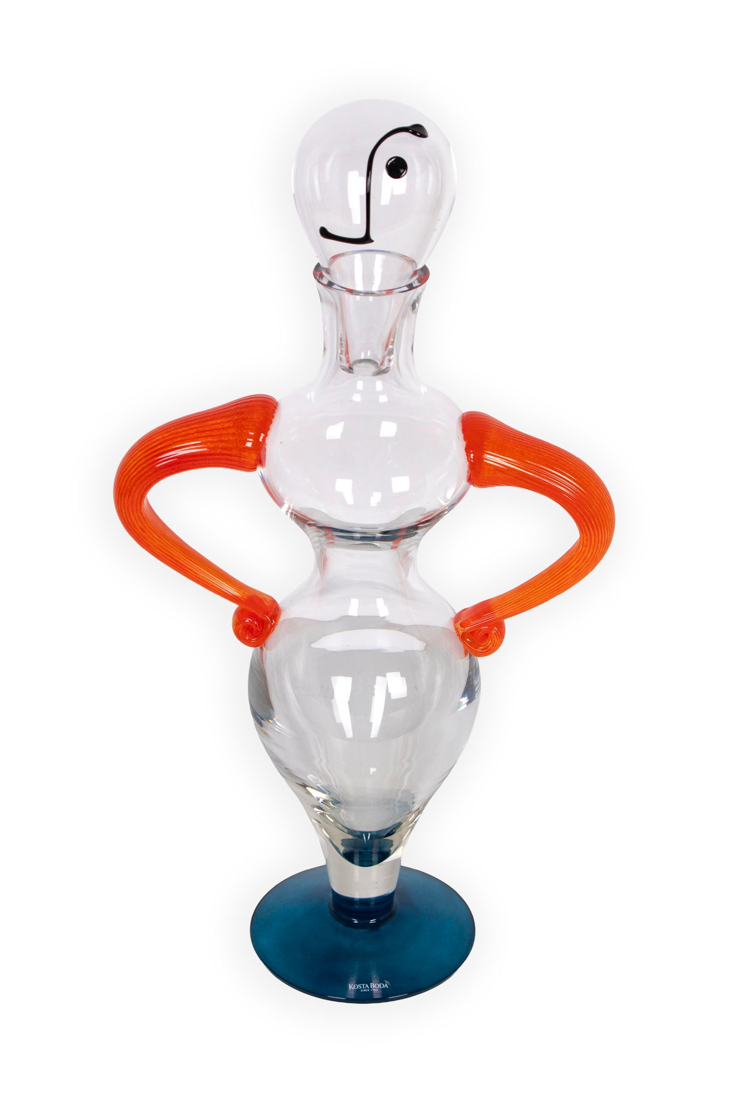Kjell Engman (b. 1946) Kosta Boda glass: Clear figure decanter with orange arm handles and removable head stopper, signed underneath, label on base, 17 ½” tall, 9” wide, weight less than 10 lbs.
