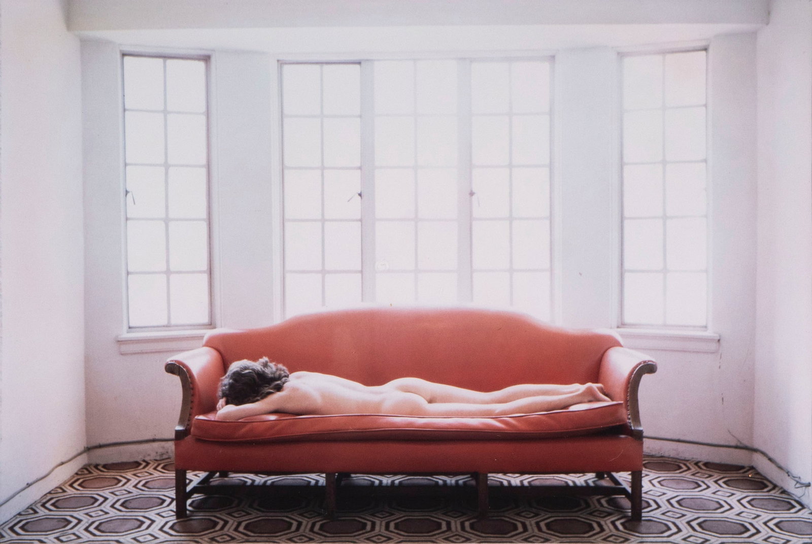 Edward Acker (b. 1955) Massachusetts: FEMALE NUDE ON A COUCH, NEW YORK CITY, 1987, color photograph, signed and dated and titled on mat, sight 6.25 x 9.25?, frame 20.50 x 16.25? with glass. Acker is known for his rooftop photograph of Mad