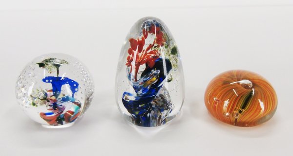 Paperweights: Art Glass (three): Three glass paperweights, two signed, two round, one egg shape, sizes 1 ¼”, 2” & 3” tall. (3)