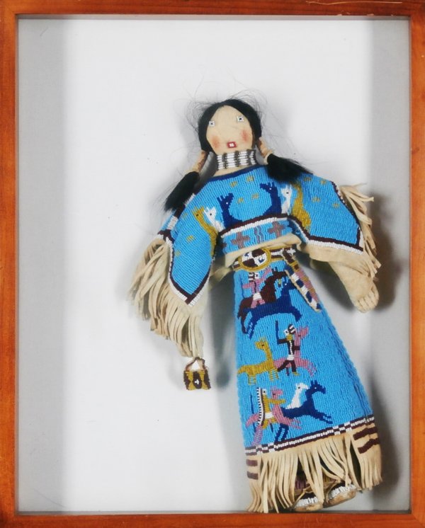Native American Beaded Doll: A female with long hair and extensively beaded tan hide outfit with pictorial scene of horses and riders, 16 ½” tall, in shadow box, in apparently good condition.