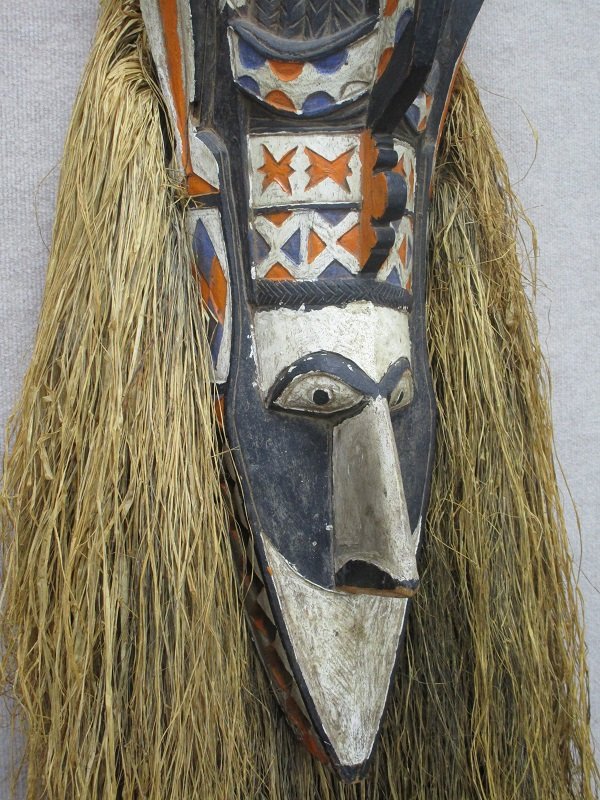 African Art: Large carved and painted wood mask with straw hair and beard, overall 70” tall, a loss at end of left horn, otherwise in good to generally good condition.