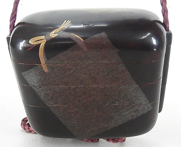 Inro: Brown lacquer with hiromaki-e and takamaki-e design, three compartments, two with removable silver lined trays, with purple cord and with ojime (bead), in apparently good condition.