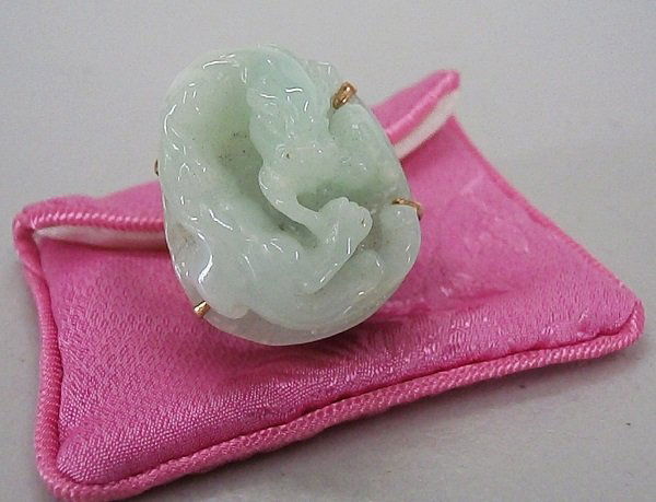 Chinese Jewelry: Celadon jade ring with traditional motif of a dragon chasing tail, in 14K yellow gold setting, in good condition.
