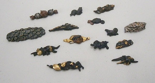 Menukis (fourteen): A collection of 14 assorted 19th century Japanese Menuki, either Edo or Meiji, some with gold highlights, all mixed metal sword fittings (Menuki were placed under the tsuka ito to help with the grip o