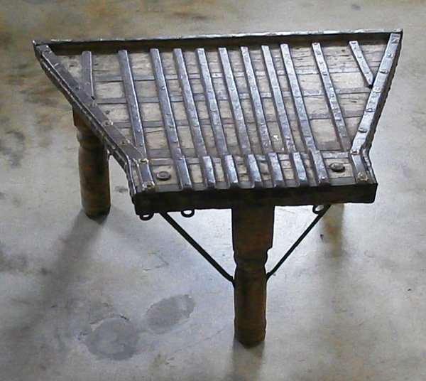 Furniture: Exotic table: Coffee or side table made of reclaimed wood door or hatch, with iron strapping and hooks, 34 x 23 x 17 ½”, in apparently good aged condition.