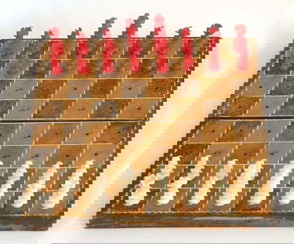 ENGLISH BONE `PEGGED´ TRAVELLING CHESS SET, circ: AN ENGLISH BONE `PEGGED´ TRAVELLING CHESS SET, circa 1860 one side stained red, the other side left natural, the chess pieces in the Old English pattern, the king 4cm high, the pawn 2cm high in