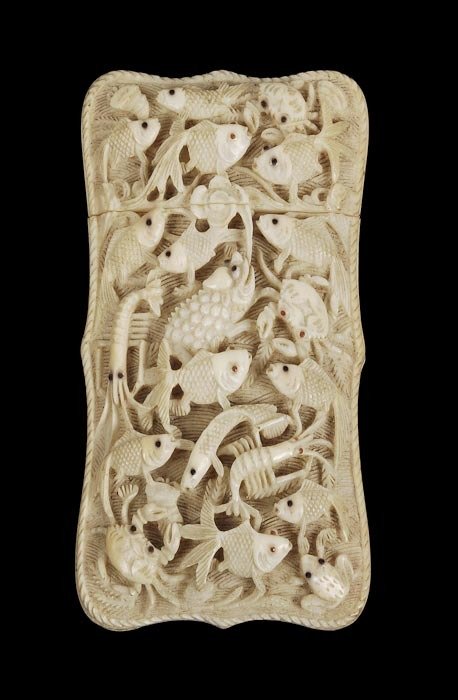 A Chinese ivory shaped rectangular card case, Cant: A Chinese ivory shaped rectangular card case, Canton, mid 19th century, carved with fish, crabs and other sealife with inset eyes amidst weed in relief on a waved ground, the back with figure
