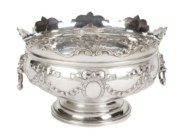 A silver two handled pedestal punch bowl by Charle: A silver two handled pedestal punch bowl by Charles Stuart Harris, London 1900? (rubbed), the shaped and moulded rim interspersed with fluted urns, the bale handles issuing from lion masks, t