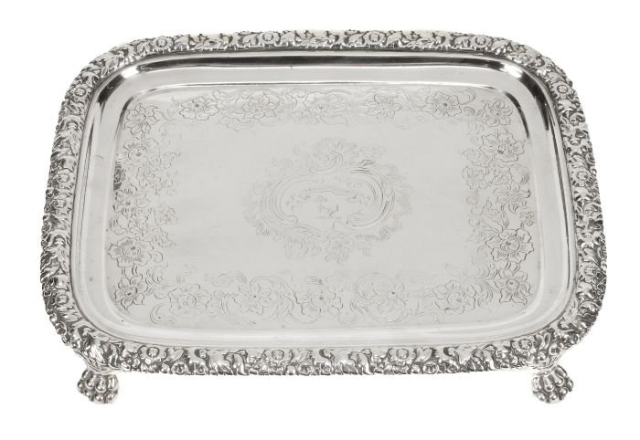 A late George III silver oblong salver by John & T: A late George III silver oblong salver by John & Thomas Settle, Sheffield 1818, engraved with a scroll and rocaille reserve and a scrolling flowering foliate border, the raised rim with chase
