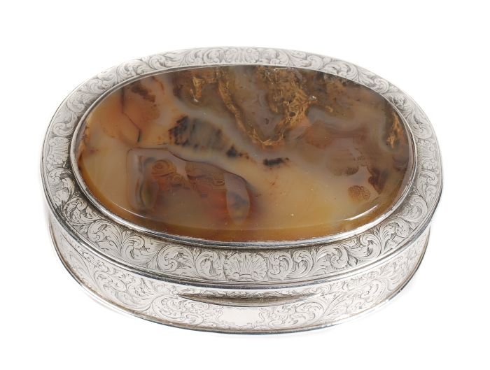 A silver and agate oval tobacco box, unmarked, ear: A silver and agate oval tobacco box, unmarked, early 18th century, finely engraved with a vacant cartouche, shells and scroll foliage, on a hatched ground, the cover and base inset with oval