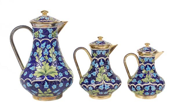 A graduated set of three Soviet Russian silver col: A graduated set of three Soviet Russian silver coloured gilt and enamel baluster jugs and covers, post 1958 .916 standard, circa 1974, with floral decoration on a blue ground, 20.5cm (8in), 1