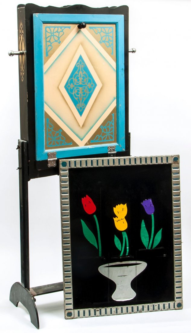 Chart (Ralph) - The Artist's Palette,: a black velvet back-cloth with four similar panels sliding down to reveal three flowers and a bowl, in ornamental wooden frame painted silver and blue, 790mm. by 610mm., and a tall painted wooden stan