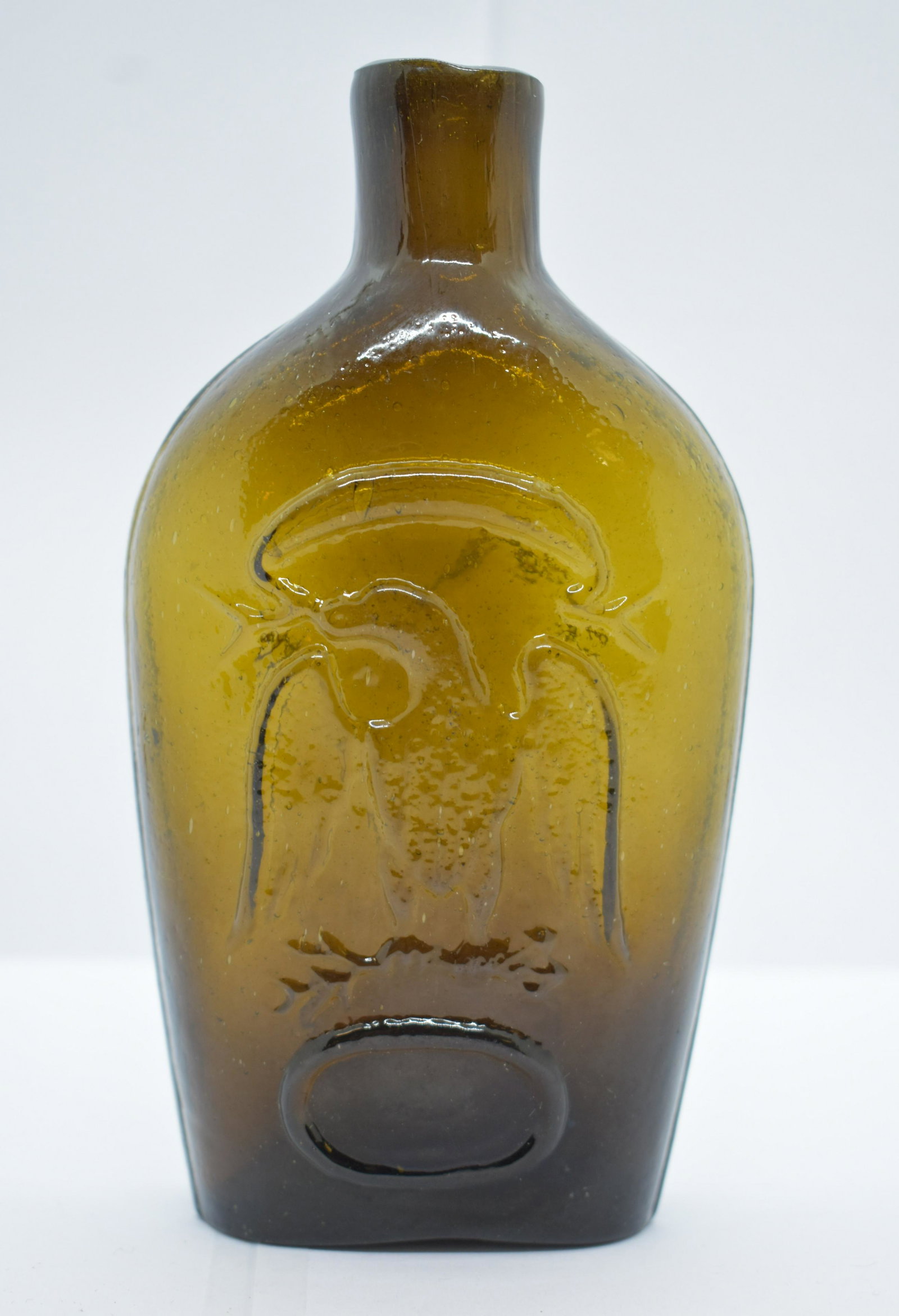 Historical Eagle Half Pint Flask - Olive Green: Hand blown into a two part mold, excellent impression on both sides. Crude sheared lip, jagged open pontil. Glass is thick, and heavy showing rich color, darker in the base. See Photos for Details. Sh