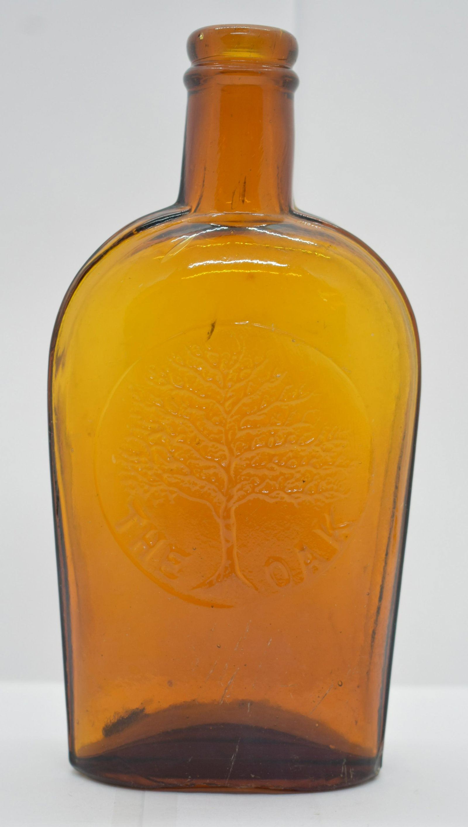 Historical Amber Glass The Oak Half Pint Flask: Hand blown into a two part mold, excellent impression. Glass is thick, and heavy showing rich color, darker in the base. See Photos for Details. Shipping Available.