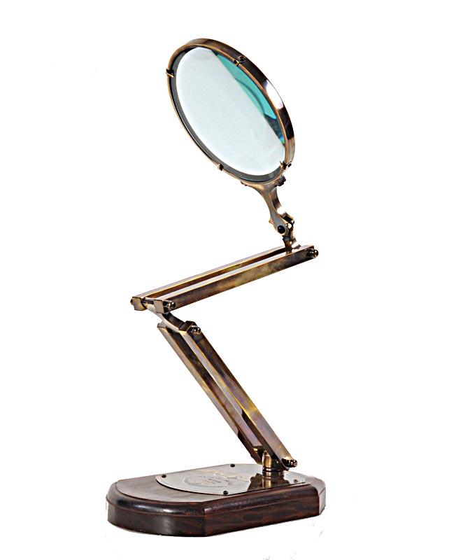 BRASS BIG ZIG ZAG MAGNIFIER GLASS W/ WOODEN BASE: BRASS BIG ZIG ZAG MAGNIFIER GLASS W/ WOODEN BASE -- Adjustable brass magnifying glass attached to a wooden base makes the perfect ?gifts for him?. The stand allows users to employ both hands while usi