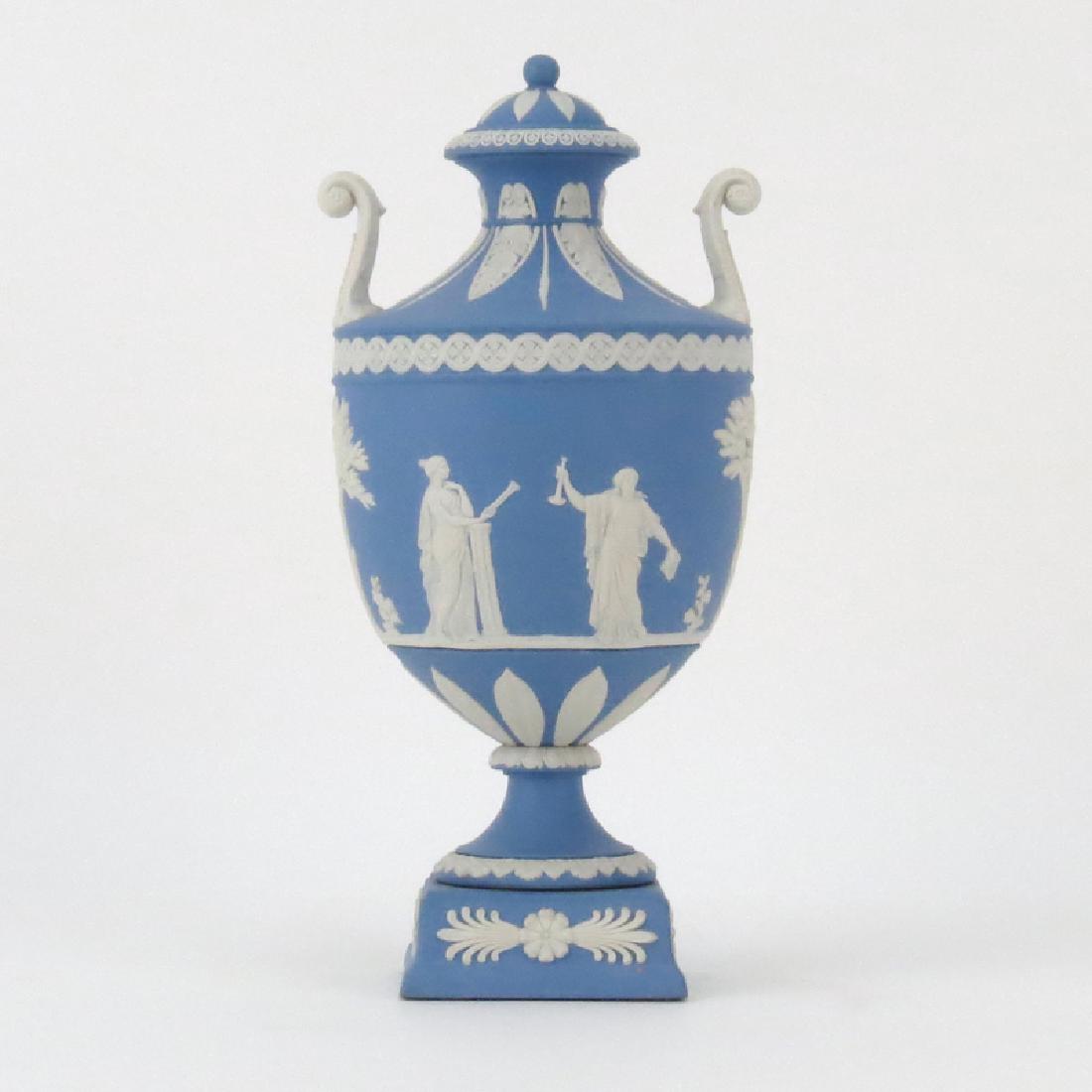 Wedgwood Jasperware Blue and White Covered Urn.: Wedgwood Jasperware Blue and White Covered Urn. Neoclassical scene relief, decorative mock handles, on raised plinth base. Stamped on underside. Needs a minor cleaning. Measures 10-3/4" H x 5" W. Ship