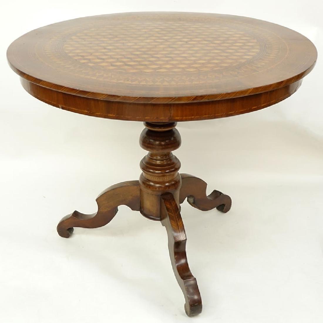 Antique American Round Carved Pedestal Table with: Antique American Round Carved Pedestal Table with Parquetry Inlaid Top. Stamped mark on underside. Light scratches to top, rubbing and scuffs. Measures 29" H x 35-3/4" Dia. Shipping: Third party. (est