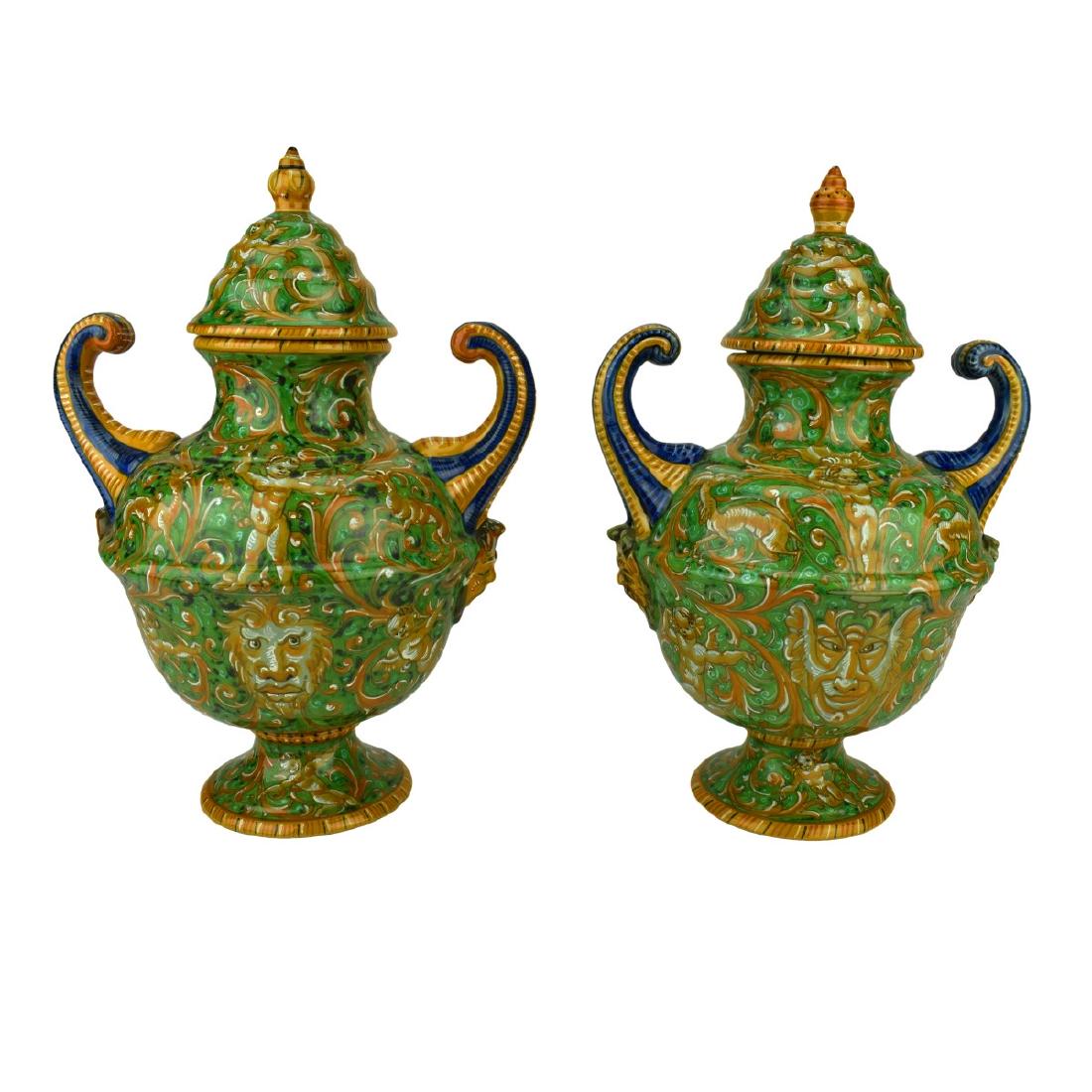 Pair of Italian Majolica Covered Urns: 20th Century Italian Pesaro Renaissance style Covered Urns with Painted Grotesques. Signed. Measure 13" H, 9" W. Domestic Shipping: $135.00 Min Est. $300.00 Max Est. $500.00 Condition: Repaired lid to