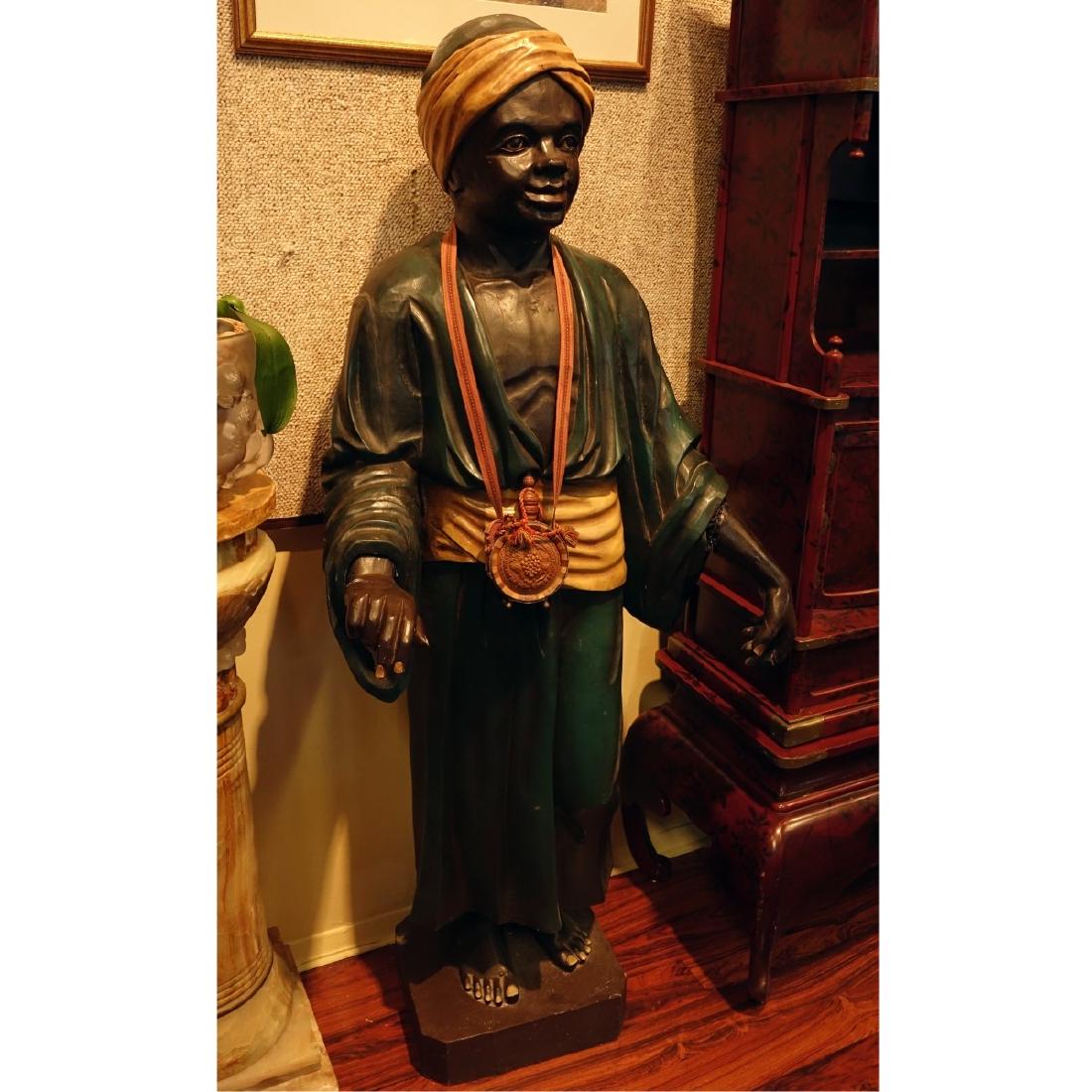 Life Size Polychrome Wood Carved Blackamoor Figure: Life Size Polychrome Wood Carved Blackamoor Figure with Necklace. Measures 64" H x 28" W Condition: Left arm has been professionally restored at the wrists, splits from age, rubbing and scratches Esti