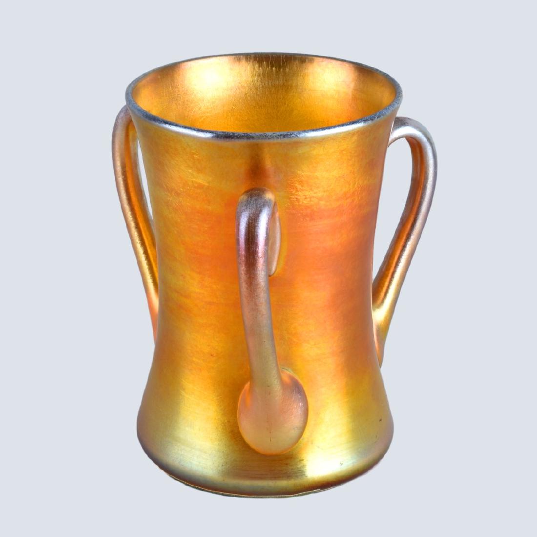 Tiffany Studios Loving Cup: Tiffany Studios, American, (es.1902 - 1938) Favrile Glass Loving Cup. Signed L.C. Tiffany - Favrile and numbered 4385C, Tiffany Favrile glass label applied to bottom side, felt fabric applied to base 