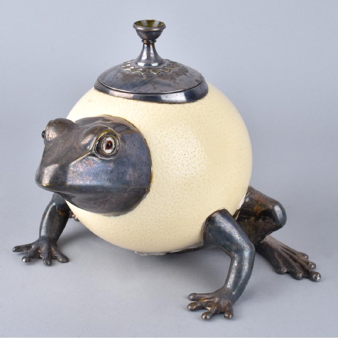 Ostrich Egg Frog: Retro Ostrich Egg and Silver Plate Frog Figure. Unsigned. Measures 6-1/2" H x 8" L. Condition: Loss to finial or in good condition. Estimate: $50.00 - $100.00 Domestic Shipping: $68.00