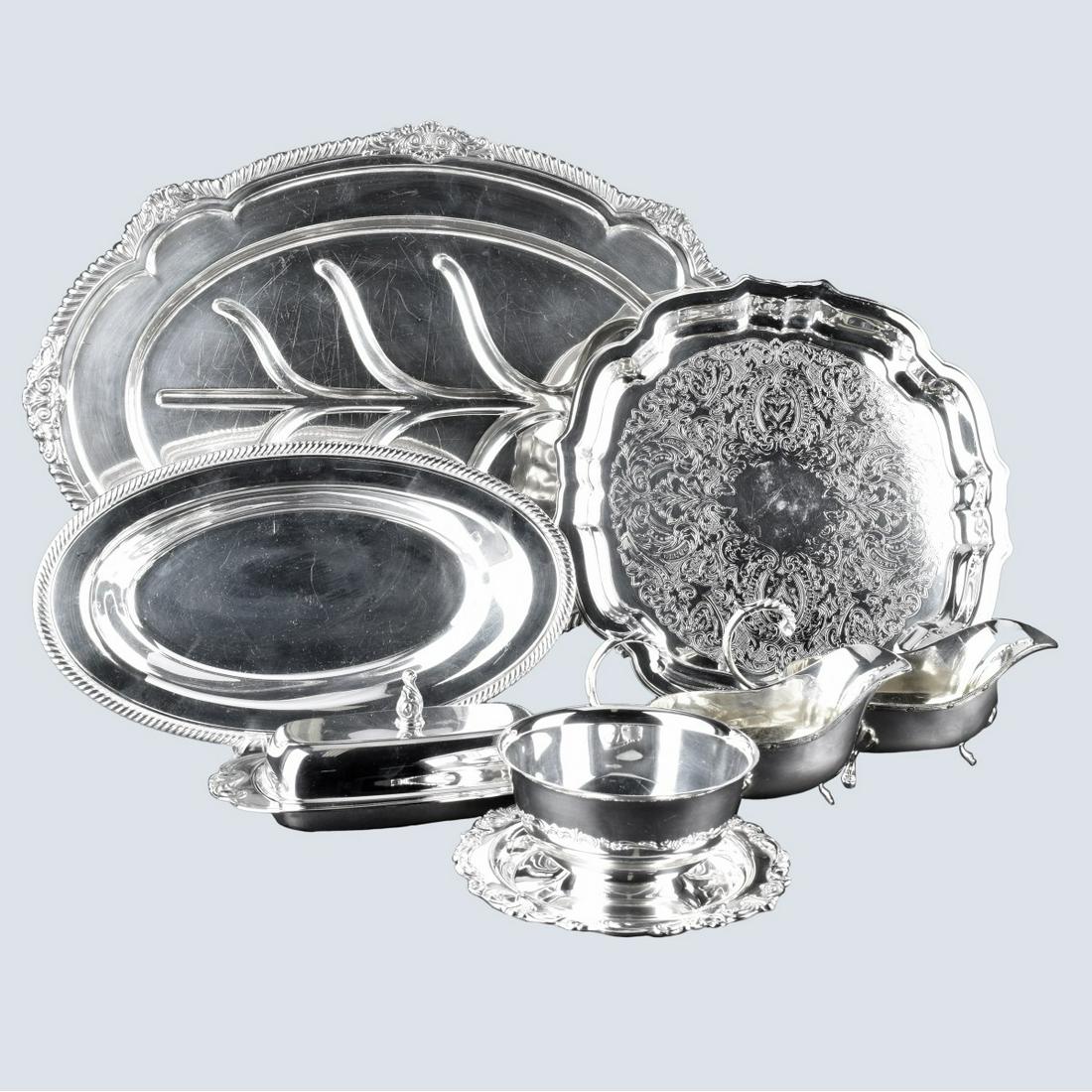 Premium Silver Plate Holloware Lot: Seven (7) Pieces Silver Plate Holloware. Includes: meat tray, round tray, dip dish, 2 sauce boats, covered butter, bread tray. One signed Gorham, the remainder unsigned. Meat tray measures 19-1/4" x 1
