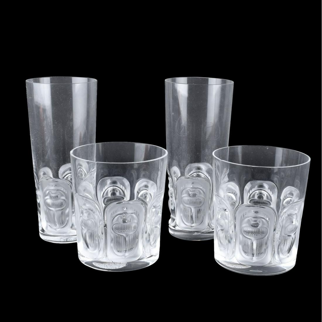 Lalique Tumblers: Lot of Four (4) Lalique "Khepri" Crystal Tumblers. Includes two 12 Oz tumblers (6-1/2" ) along with two13 Oz tumblers (4"). Decorated with frosted panels and scarab decor. Signed and Christies Auction