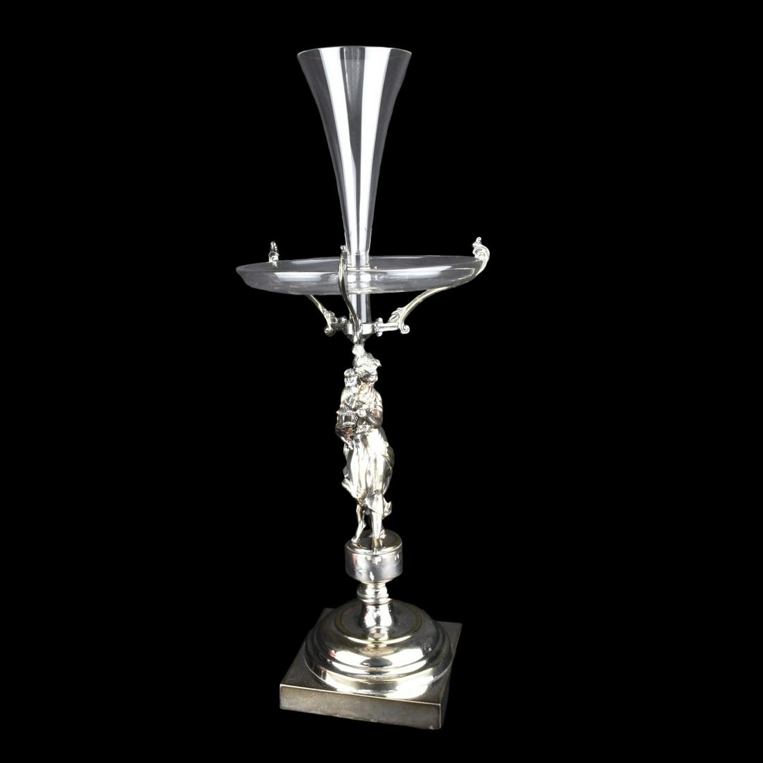 Crystal and Brass Epergne: Crystal and Brass Epergne. Woman holding an instrument. Unsigned. Measures 24" H x 10" D Condition: As Is condition, glass center hole cracked and chipped. Estimate: $50.00 - $150.00 Domestic Shipping