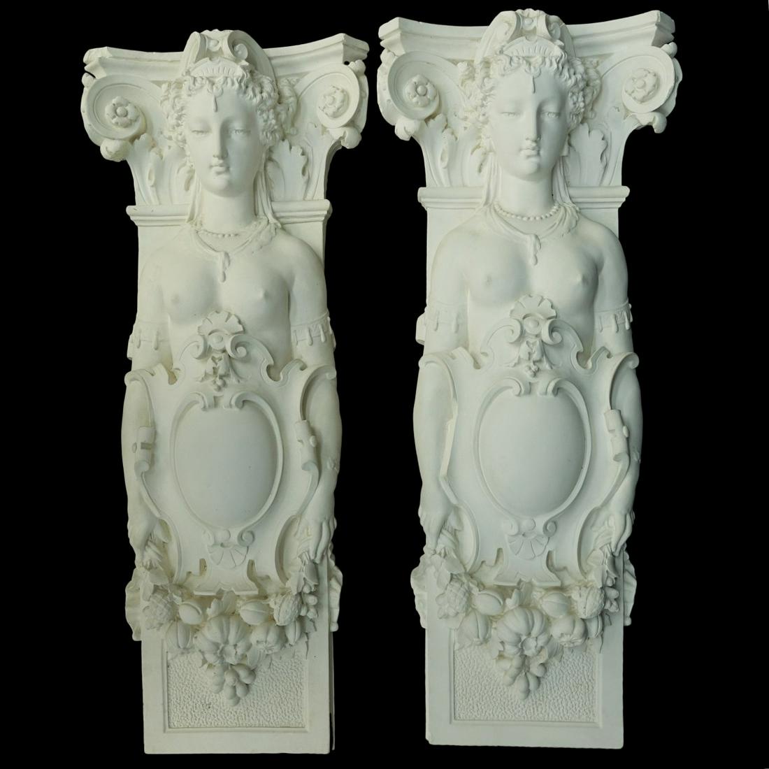 2 Neo Classical Architectural Wall Pilasters: Two (2) Neo-Classical Architectural Wall Pilasters. Half Nude Women holding garland of grapes and flower around a shield on Raised Panel. Unsigned Plaster. Measures 36-1/4" H x 15-1/4" W Condition: Go