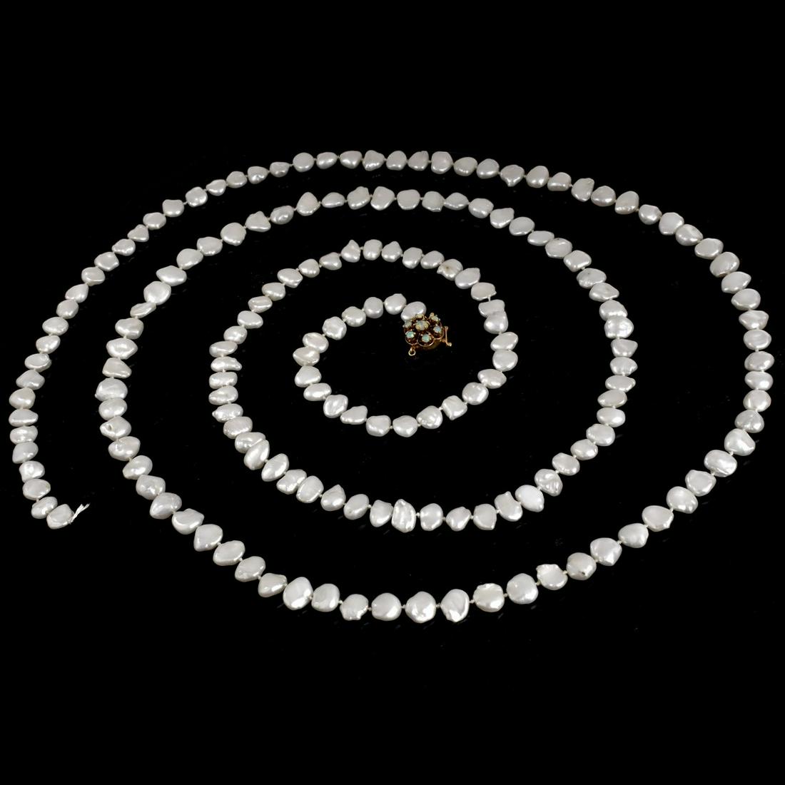 Pearl, 14K and Opal Necklace: Vintage 62" Long Baroque Pearl Necklace with 14 Karat Yellow Gold and Small Opal Clasp. Stamped 14K. Pearls measure 7.0-9.0mm. Approx. weight: 84.7 grams. Condition: Good vintage condition. Needs to b