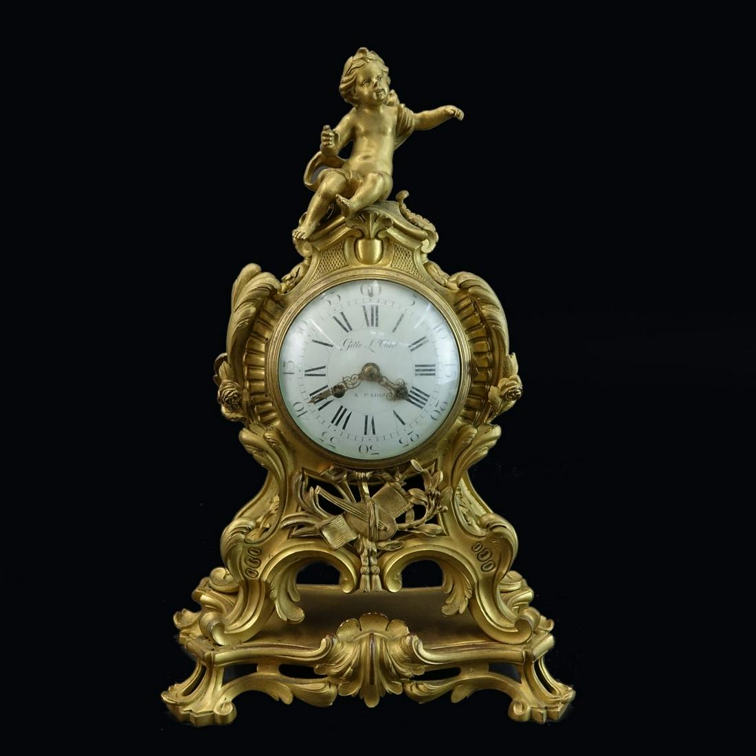 Gille L'Aine Louis XVI Style Mantle Clock: Antique Gille L' Aine Louis XVI Style Gilt Bronze Mantle Clock. Roman numerals and Arabic seconds with markers mark on enamel dial, scroll foliage motif with cherub finial. Marked S. Marti on the move