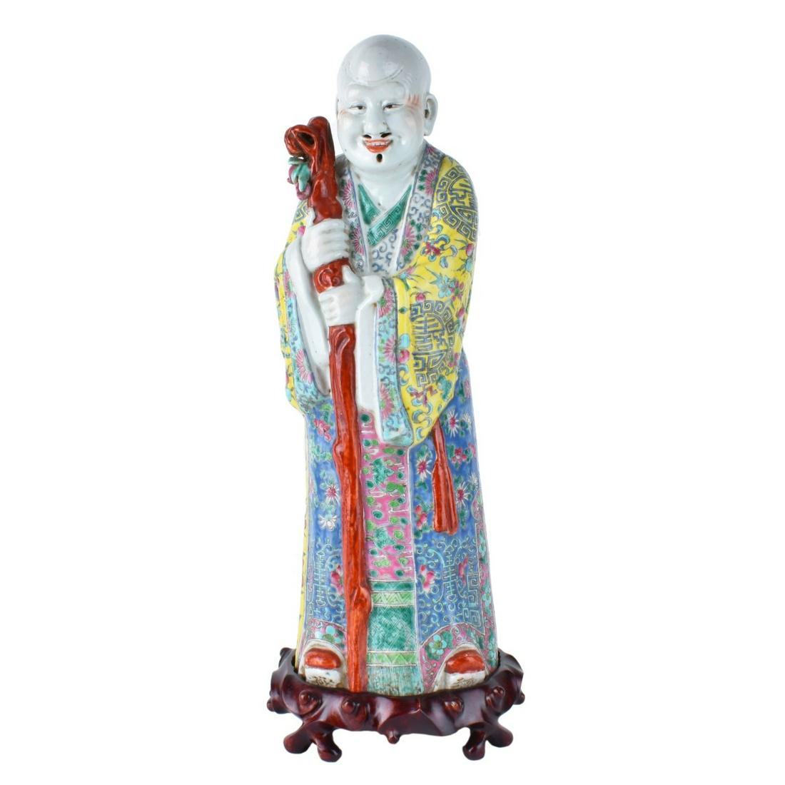 Chinese Immortal with Staff: Large Chinese Famille Rose Export Porcelain Immortal with Staff on Wooden Stand. Signed to base. Measures 17-3/4" H (figurine), stand measures 2" x 7". Condition: Small loss near staff, wear consisten