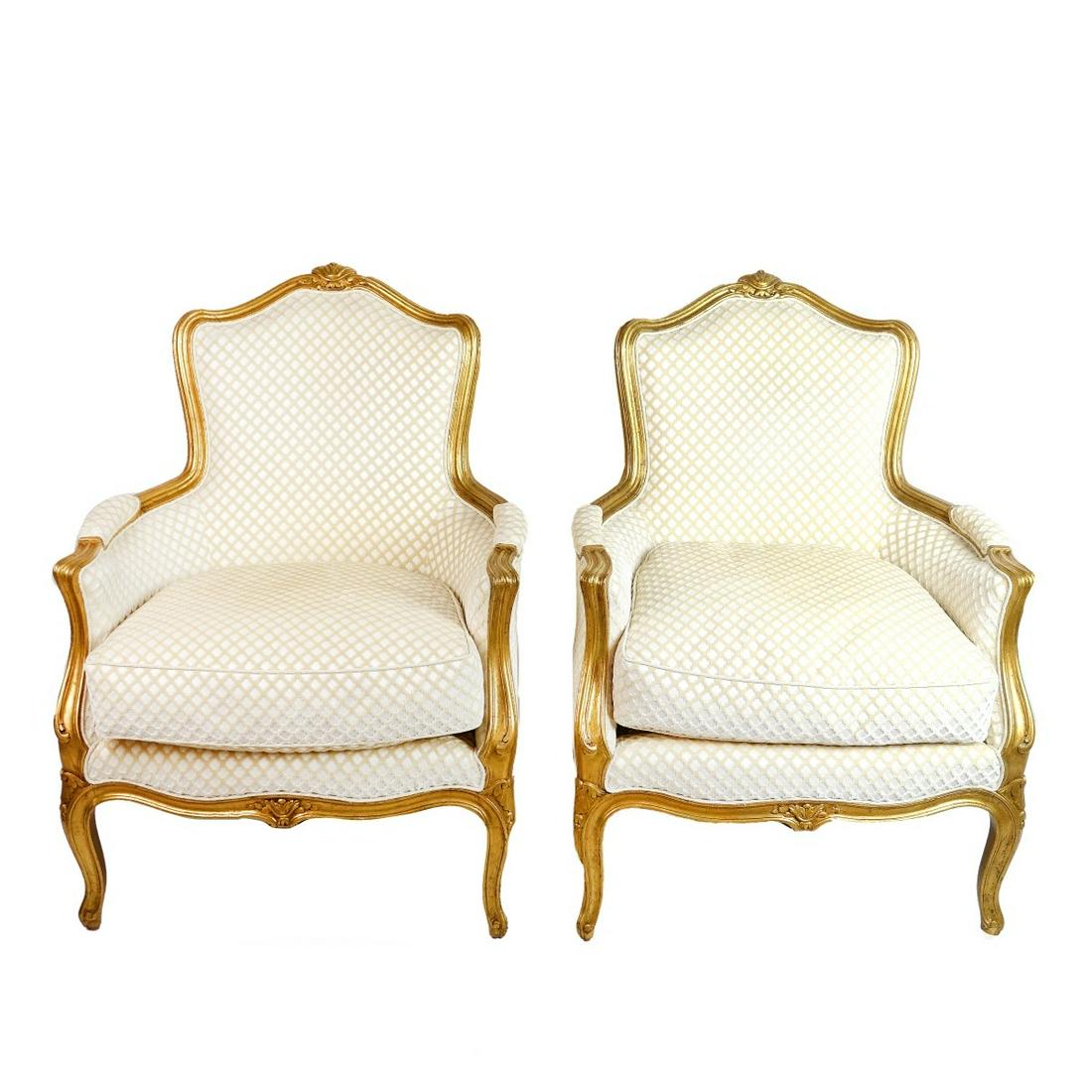 Louis XVI Style Gilt Carved Bergere Chairs: Pair of Mid 20th Century Louis XVI Style Gilt Carved and Scalamandre Upholstered Bergere Chairs. Curved back rest with down cushion, carved frame with floral center crests and swirl motif, armrest des