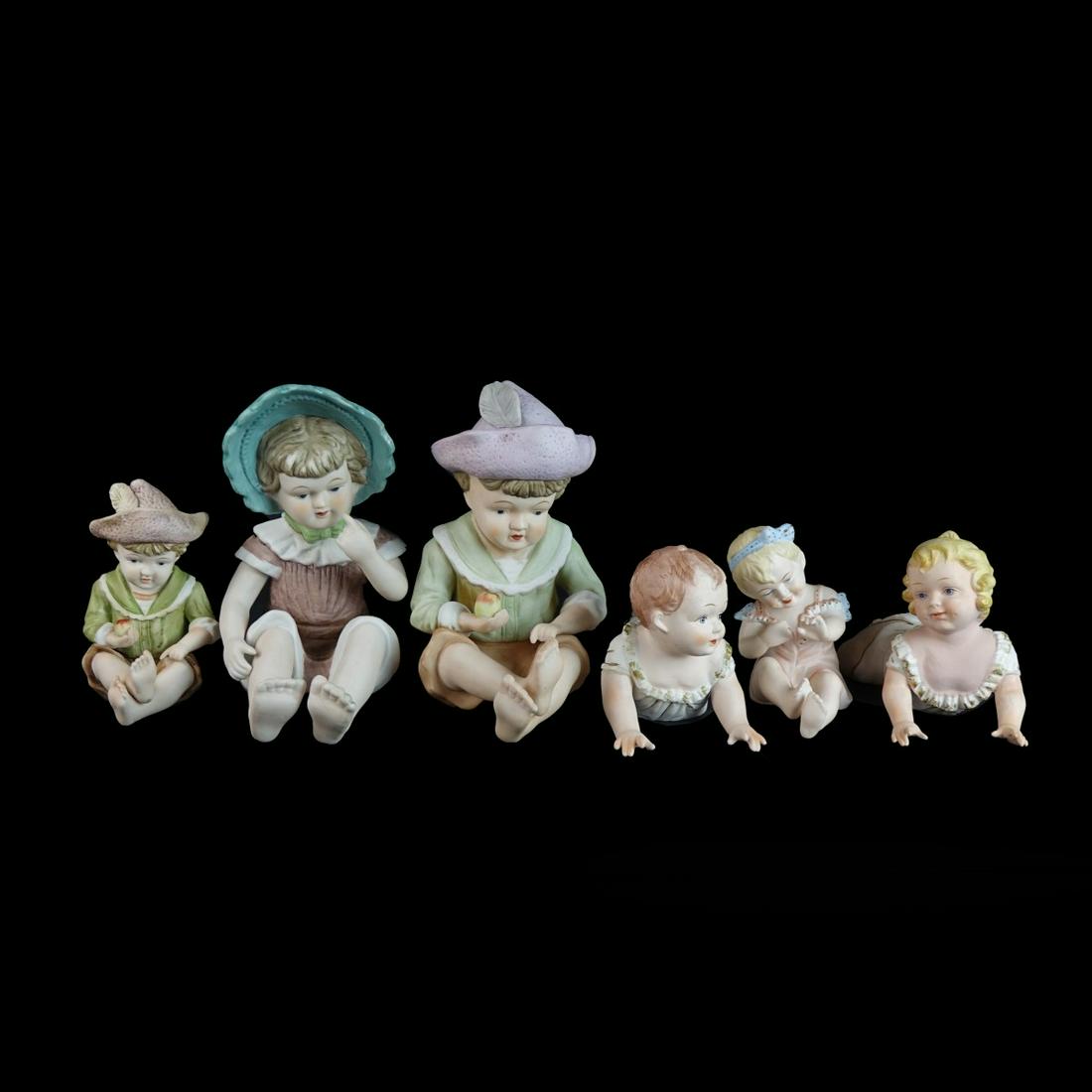 Six (6) 20th C. Piano Babies: Group Lot of Six (6) 20th Century Porcelain Piano Babies. One is marked KPM, a few others with marks on the bottom side. Tallest measures 9-3/8". Condition: Good condition. Estimate: $50.00 - $150.00
