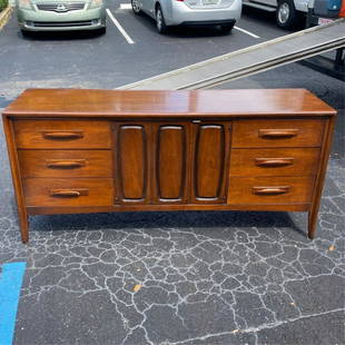 Broyhill Premier Dresser and Mirror: Modern Broyhill Premier Walnut Credenza/Dresser together with Matching Tri-Fold Mirror. Dresser has original label attached. Dresser consists of six drawers and stands on tapering legs. Dresser measur