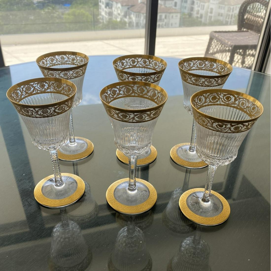 St. Louis "Thistle" Wine Glasses: Set of Six (6) St. Louis "Thistle" Crystal Claret Wine Glasses. Signed. Gilt encrusted embellishment and faceted stem. Measures 5-5/8" x 2-7/8". Condition: Like new condition. Needs a routine cleaning