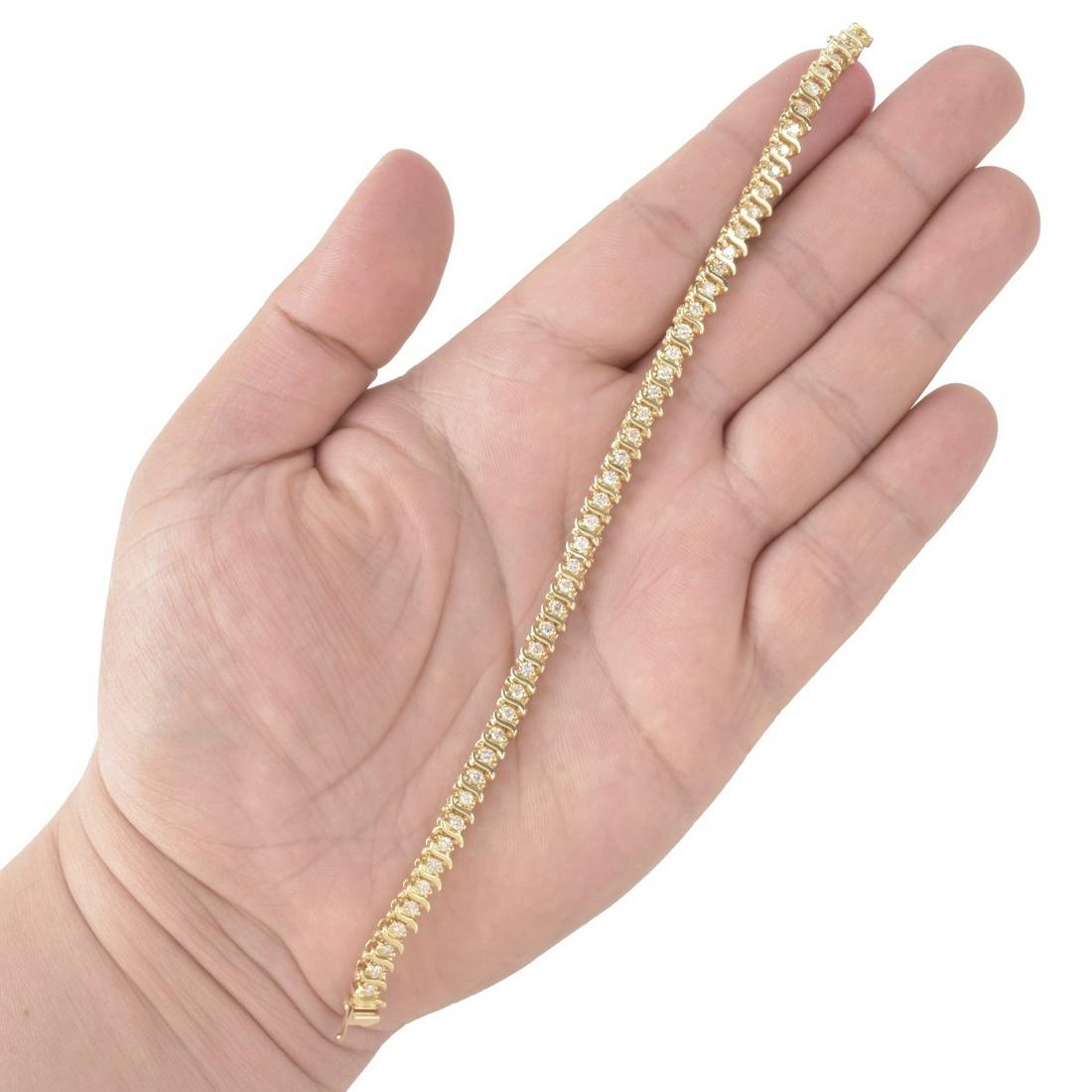 Diamond and 14K Bracelet: Approx. 2.50 Carat TW Forty Eight Round Brilliant Cut Diamond and 14 Karat Yellow Gold Tennis Bracelet. Diamonds I-J color, SI1-SI2 clarity. Stamped 14K. Measures 7-1/8"L, 3/16" W. Approx. weight: 15.