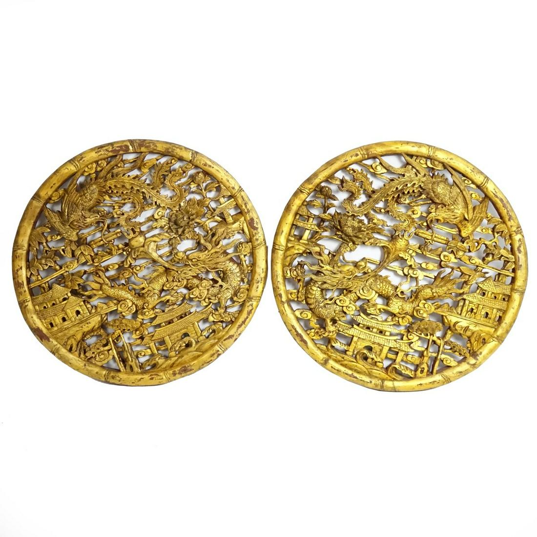 Chinese Wall Appliques: Pair of Large Large Antique Chinese Parcel Gilt Reticulated Deep Carved Wall Appliques. Intricately detailed with birds, pagodas, and dragon. Measures 31-1/4" dia. 2" D. Condition: Rubbing to the gilt