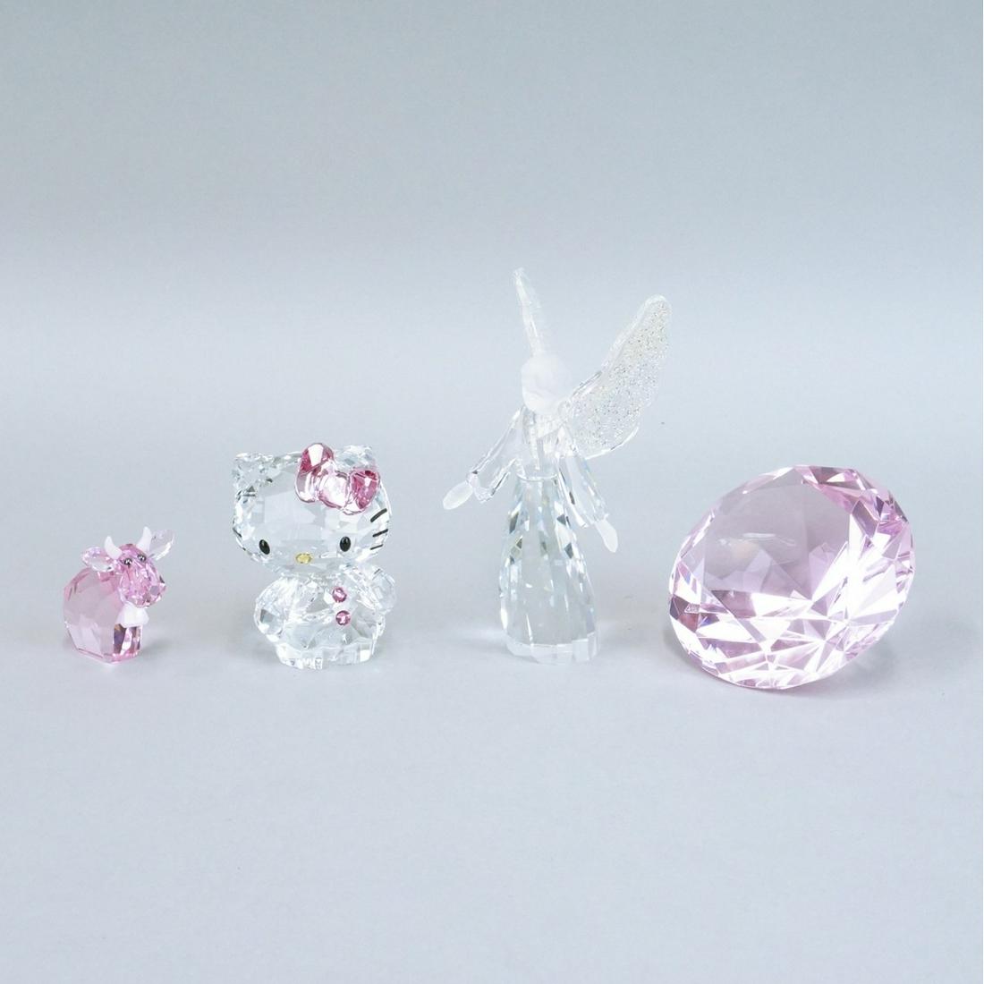 Swarovski Figurines: Lot of Four Swarovski Crystal Figurines. Includes a angel figure, diamond paperweight, hello kitty figure, and a lovlots pinky mo cow. Paperweight is not signed. Angel measures 4-1/2" x 2-1/4". Kitty